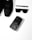 A collection of black fashion accessories including a pair of black sneakers, a black pen, black sunglasses, and a black smartphone with an artistic design on its case, arranged neatly on a white surface.