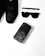 A collection of black fashion accessories including a pair of black sneakers, a black pen, black sunglasses, and a black smartphone with an artistic design on its case, arranged neatly on a white surface.