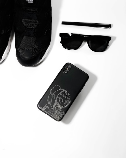 A sleek display of phone accessories and sneakers with a black, red, and orange manga-inspired background.