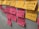 A collection of sticky notes are attached to a wall. Yellow and pink notes feature handwritten text in French. Some phrases are stressed, indicating important points or concerns.