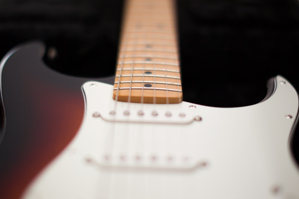 white and brown electric guitar