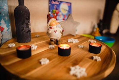 Eco-conscious Christmas figurines painted in vivid hues arranged on a festive holiday table.