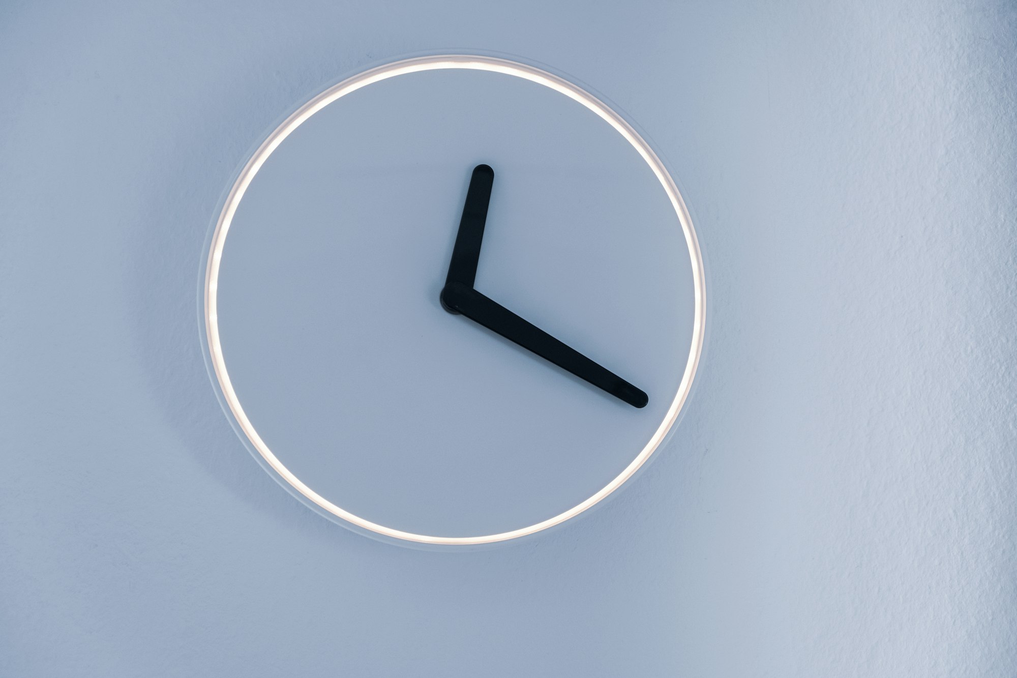 Basic clock with no numbers on blue wall