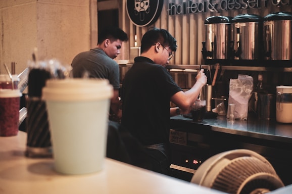 A friendly customer service representative wearing a headset, ready to assist with bulk beverage orders.