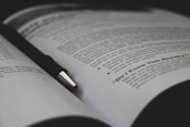 An open book with financial graphs and notes, representing education and learning in trading.