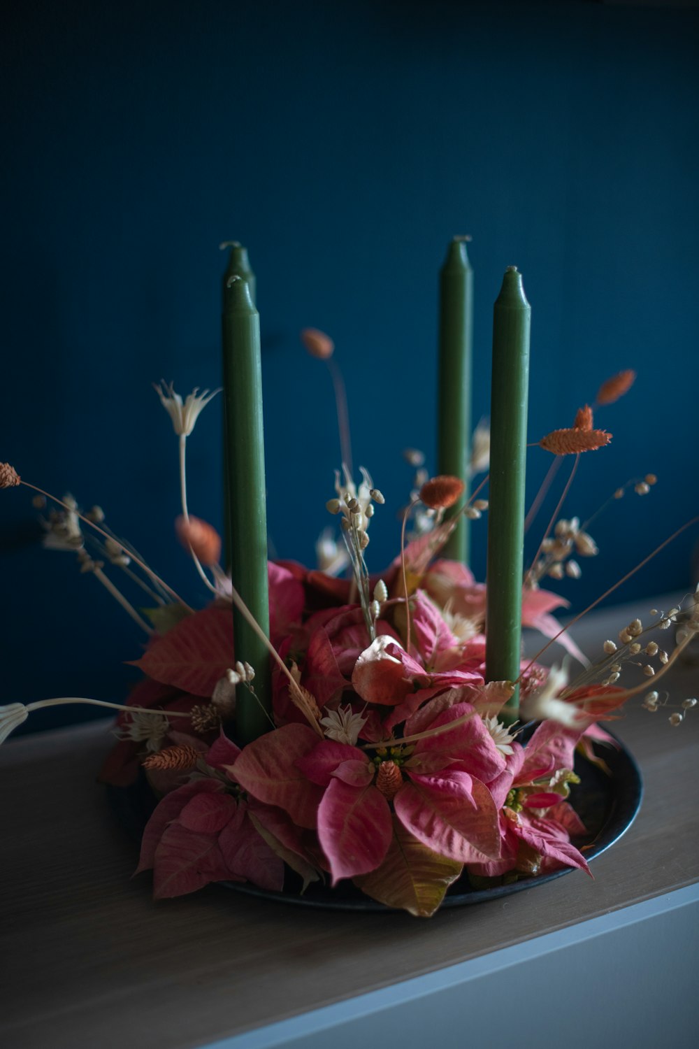 a plate with candles and flowers on a table