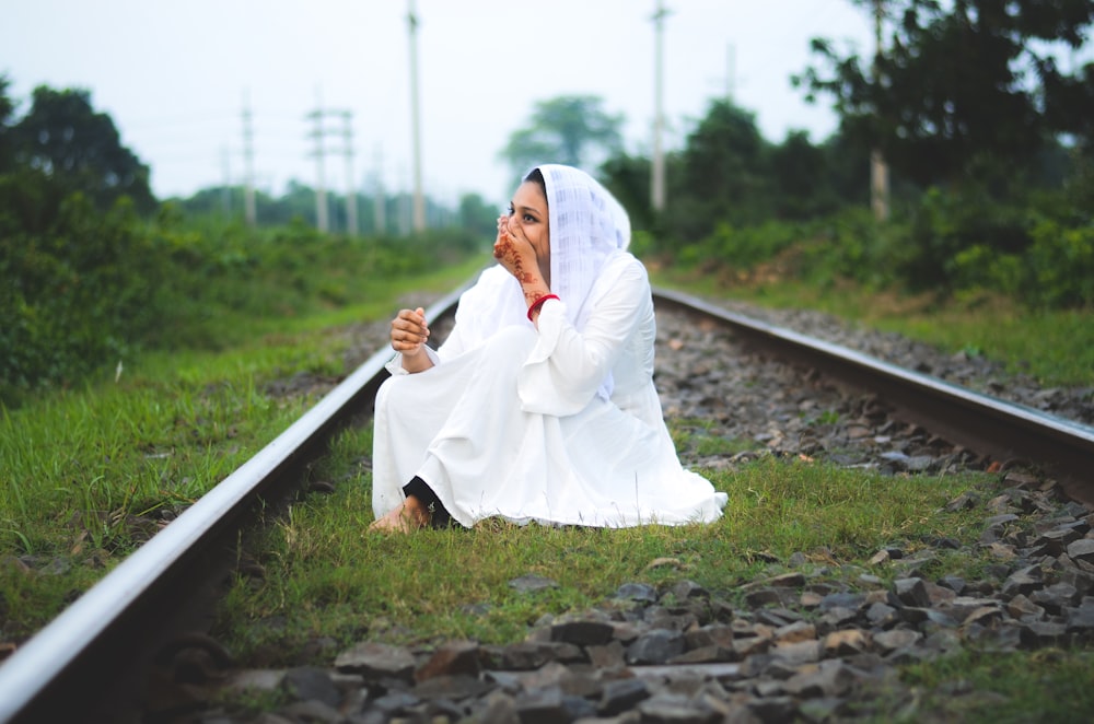 woman sitting on train rail