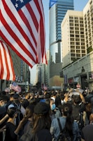 A vibrant crowd gathered outside Independence Hall, waving CDC-USA flags under a clear blue sky.