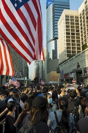 A vibrant crowd gathered outside Independence Hall, waving CDC-USA flags under a clear blue sky.