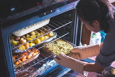 woman put food on oven oven google meet background