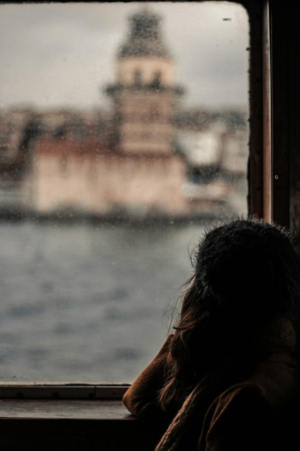 woman leaning on glass window