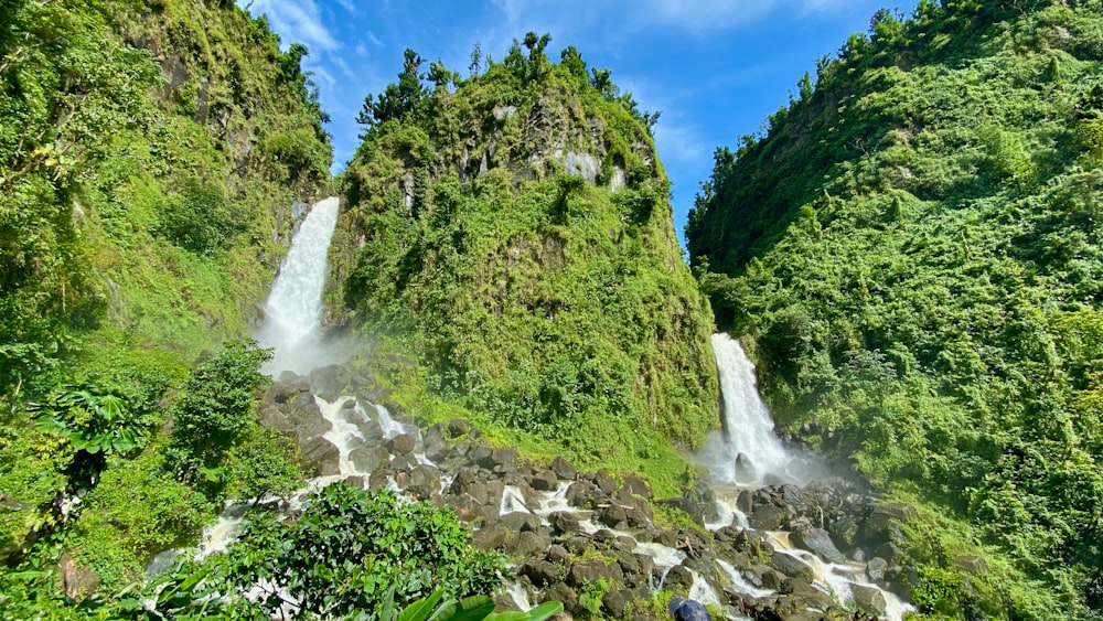 waterfalls and grass mountain during day