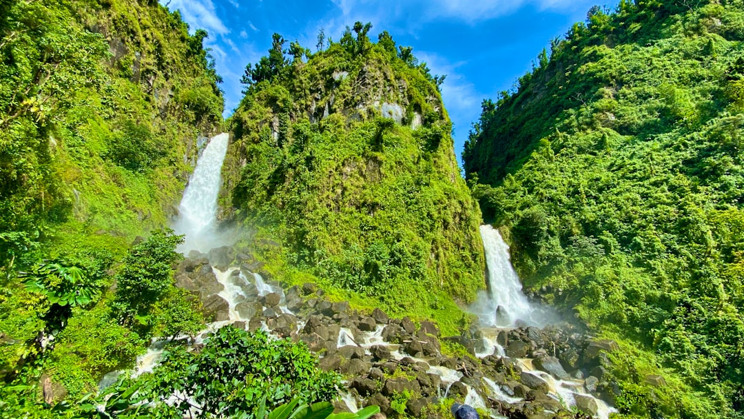 waterfalls and grass mountain during day