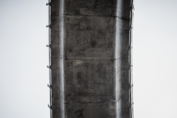 Close-up of a structural inspection with an engineer using specialized equipment on a concrete bridge.