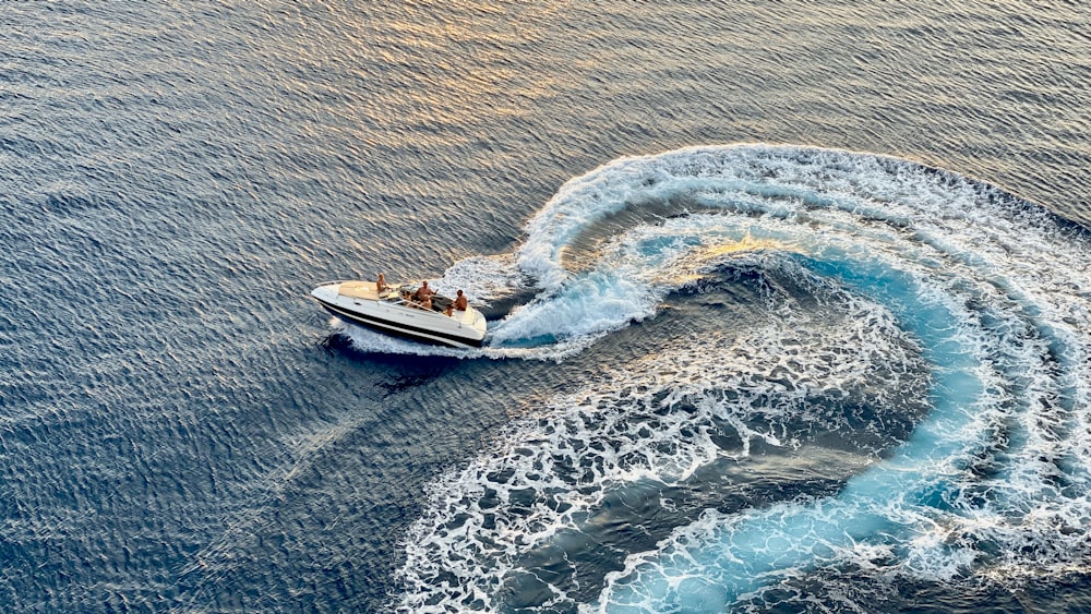 Yate blanco que corre sobre agua de mar