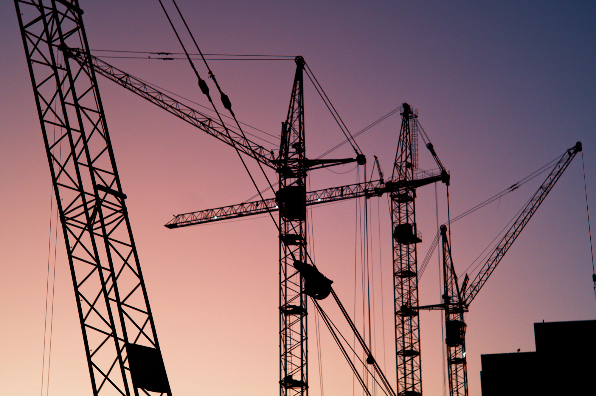 Tower cranes above a high-rise site at dusk