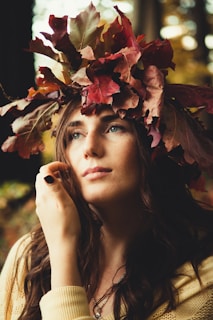 portrait of woman wearing yellow sweater with red and brown leaves headdress