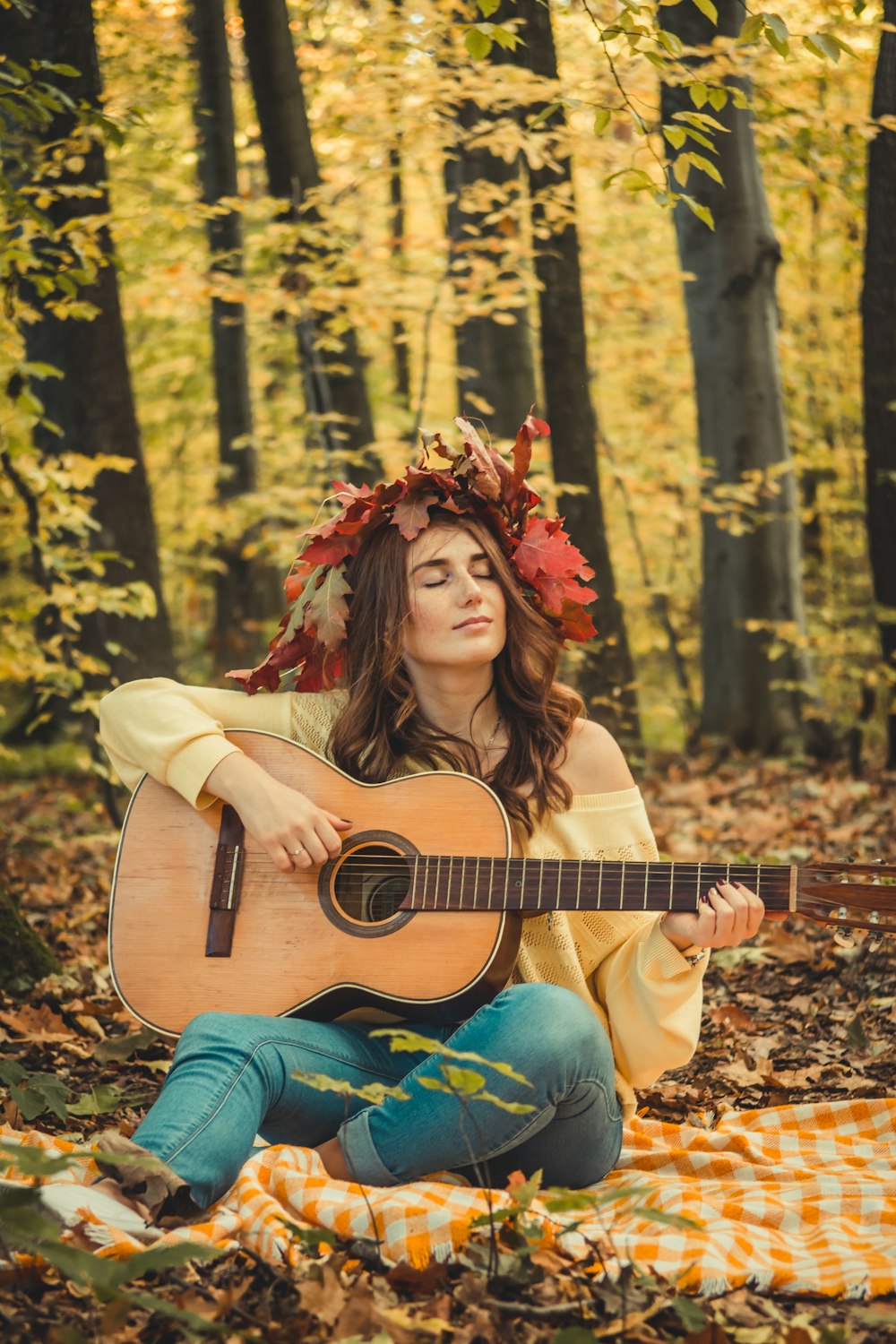 woman in yellow off-shoulder top playing guitar