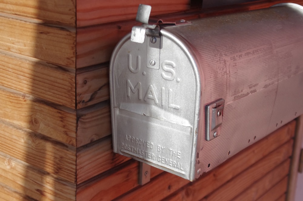 silver mail box beside wall