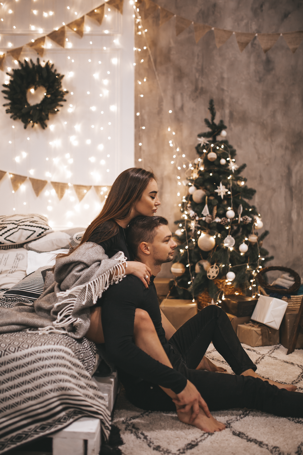 couple sitting beside Christmas tree