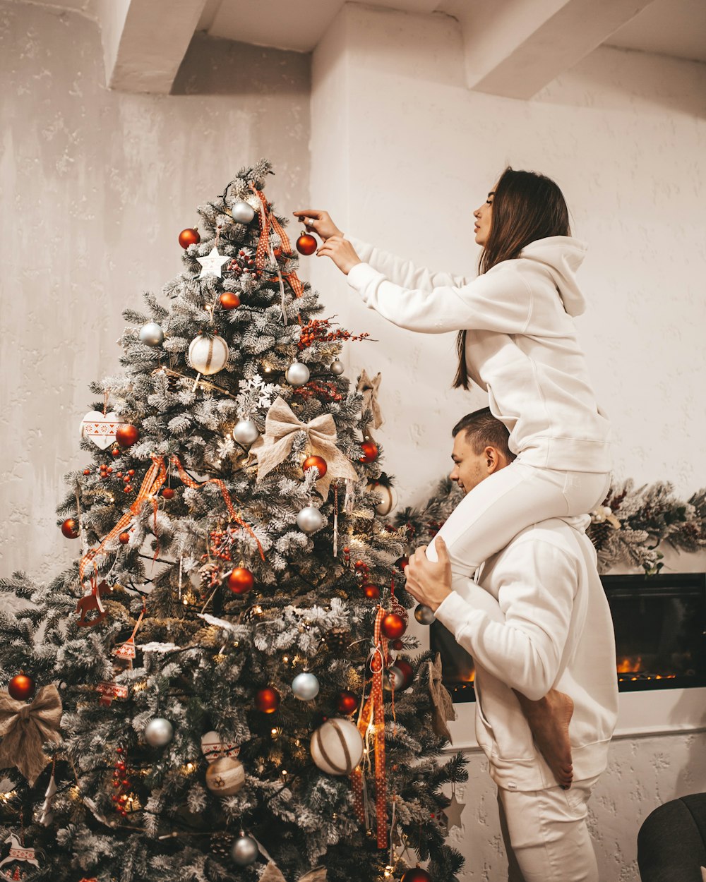 femme mettant une boule de Noël sur l’arbre de Noël