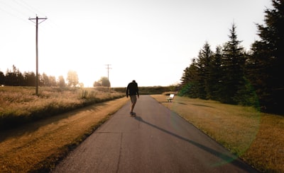 person standing in the middle of the road near trees north dakota teams background