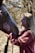 A smiling guest gently petting a horse in the sunlit stable at Liderówka.