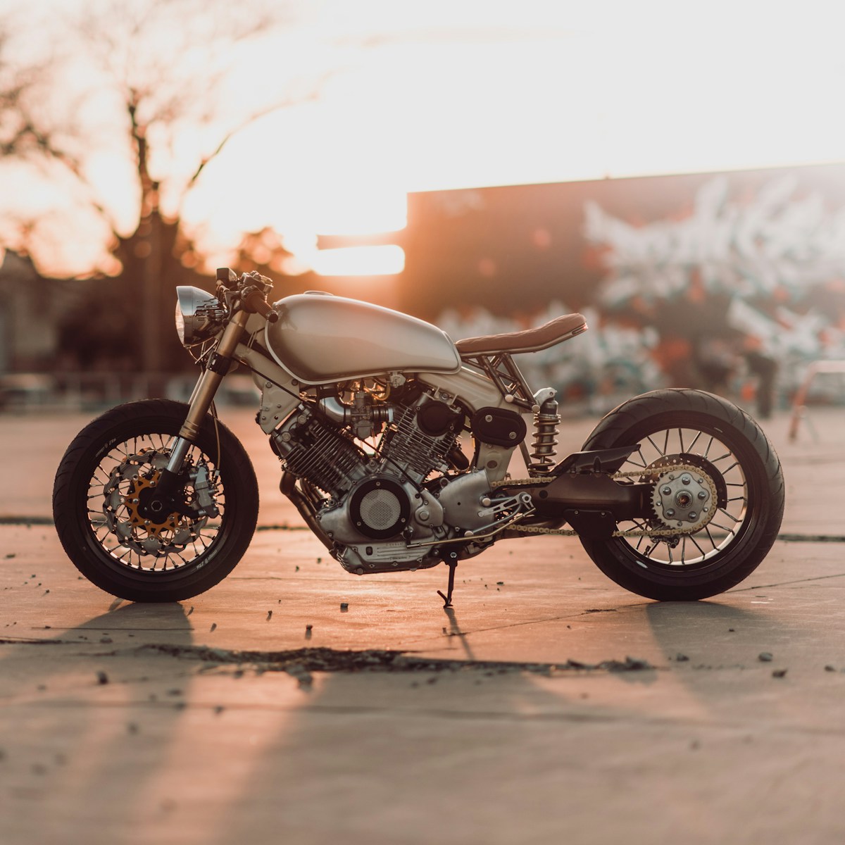 A silver unbranded motorcycle sits on a brightly lit backdrop