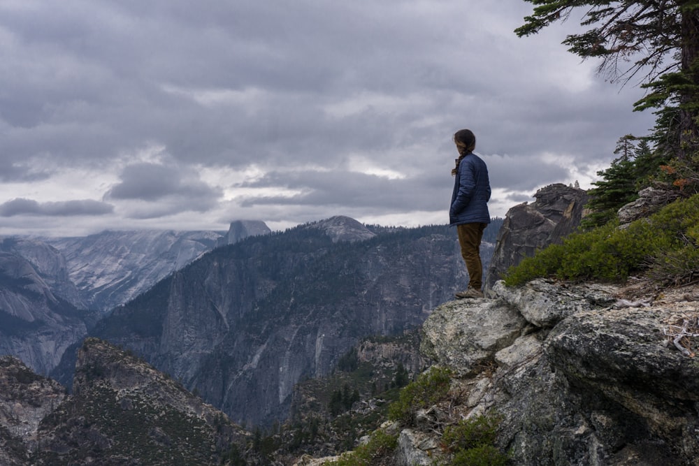 person standing on edge cliff during daytime