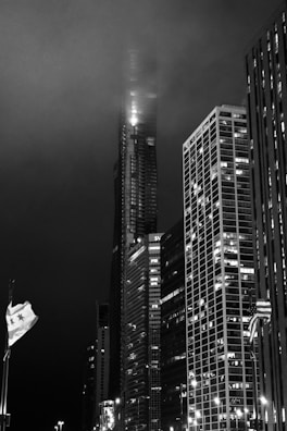 Black and white photo of city skyscrapers piercing through fog.