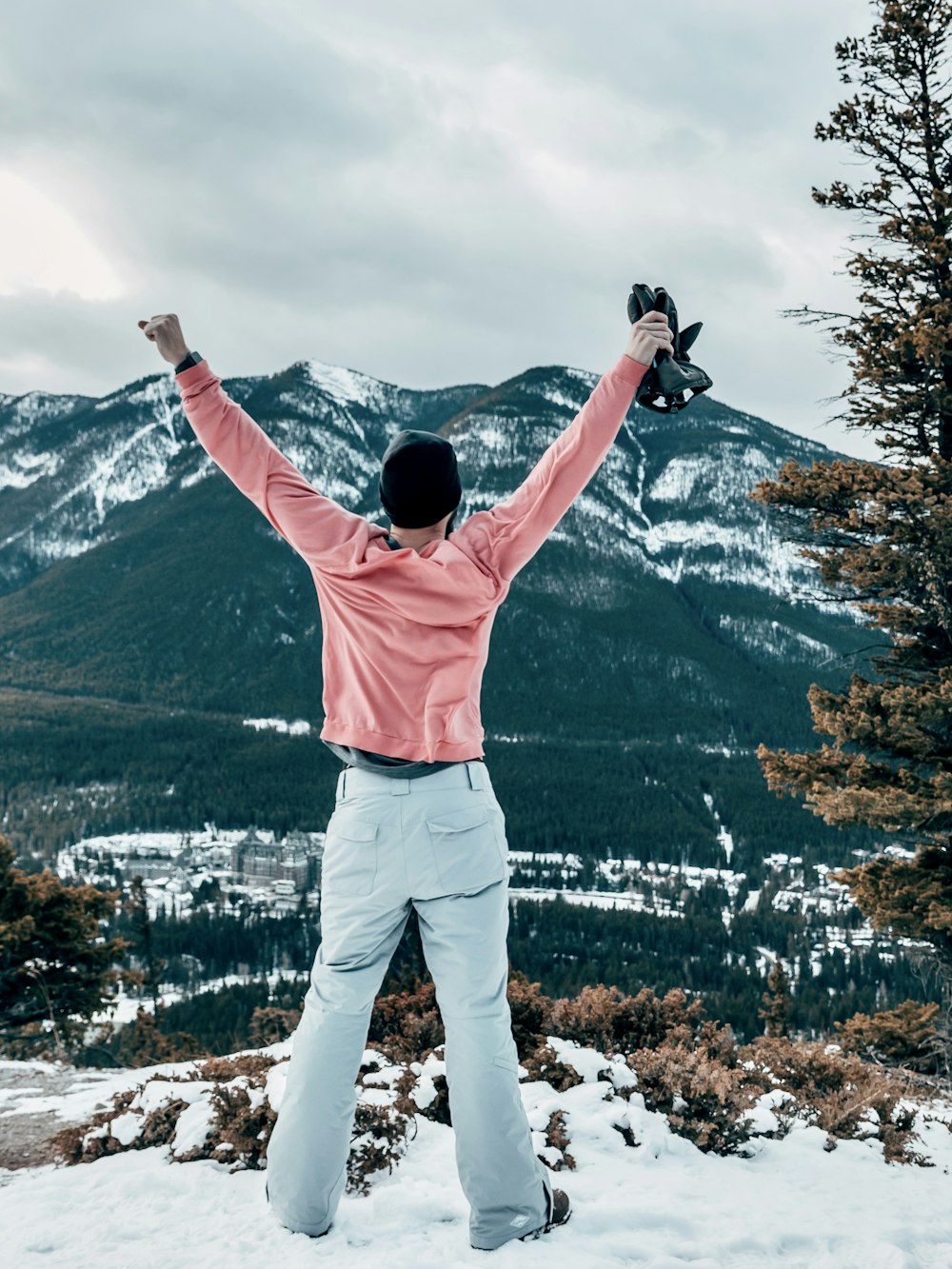 Sehen Sie sich die Fotografie eines Mannes an, der tagsüber mit weit ausgebreiteten Armen auf dem Berg steht