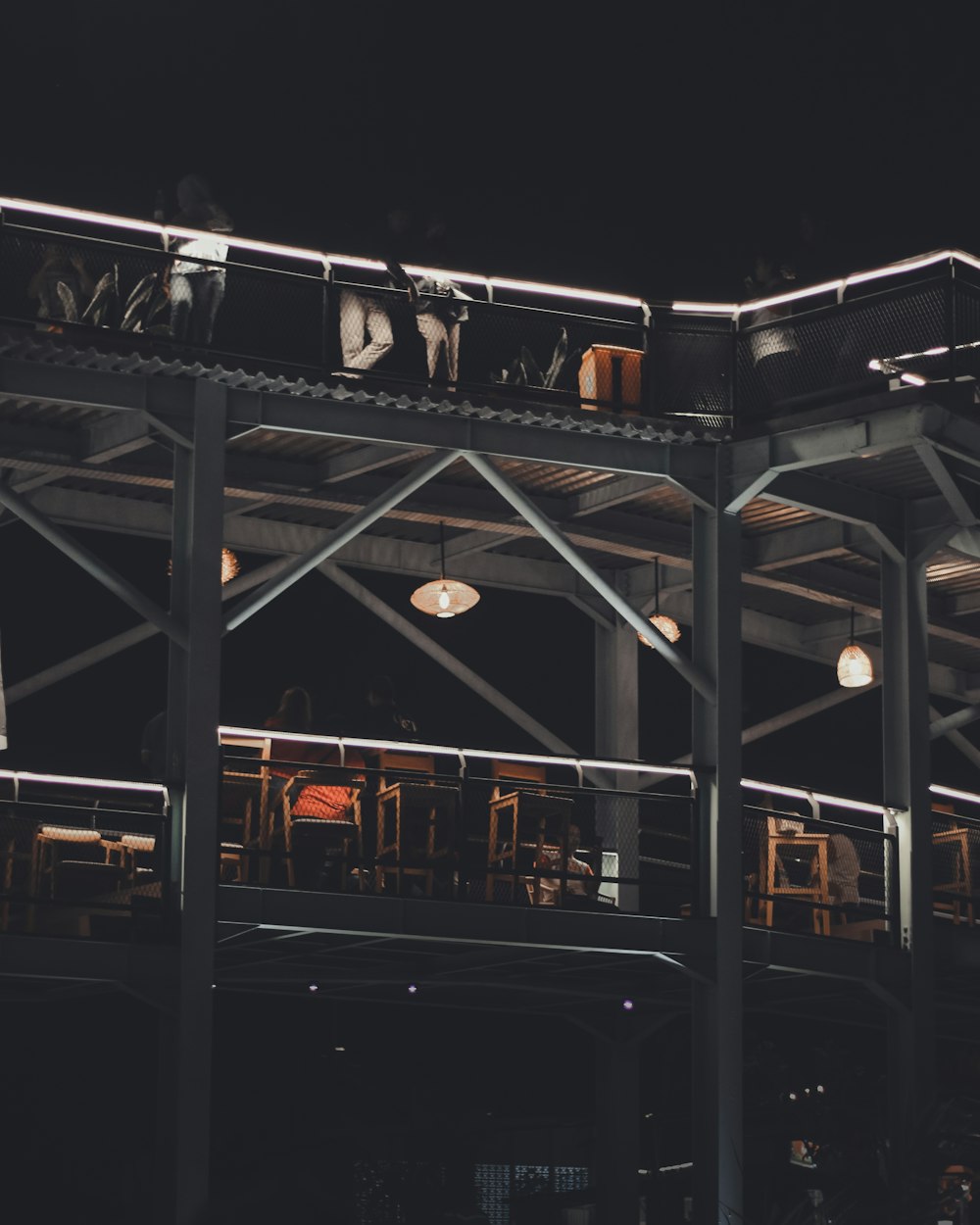 a group of people sitting at tables under a roof