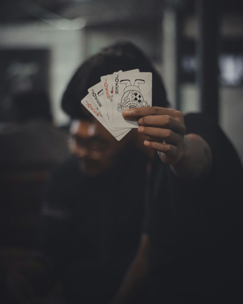 view photography of person showing four Joker playing cards