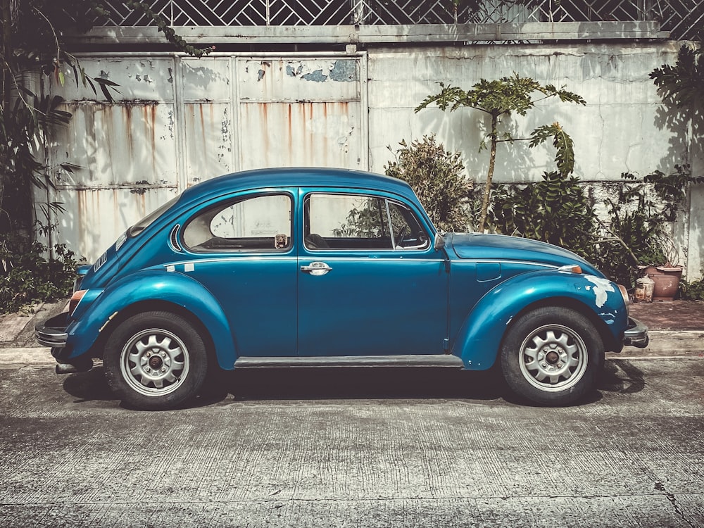 blue Volkswagen Beetle coupe parking near road