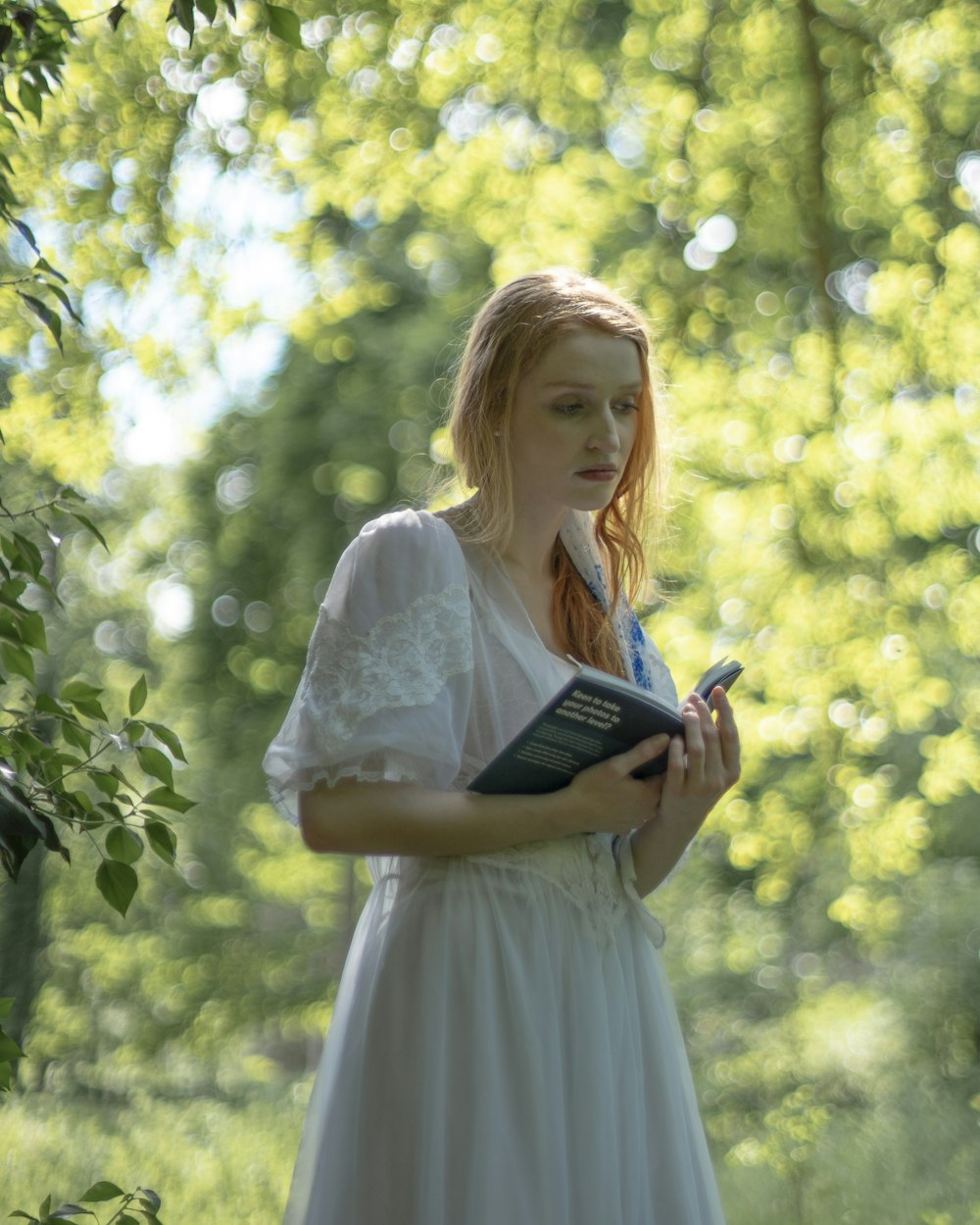 woman wearing white dress reading book