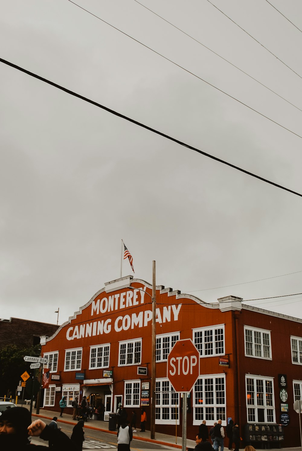 pessoas caminhando perto do edifício da empresa de conservas de Monterey durante o dia