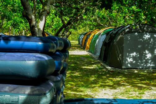 A spacious outdoor tent setup with mats and camping gear arranged neatly.