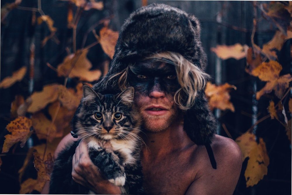 view photography of person holding black and white cat