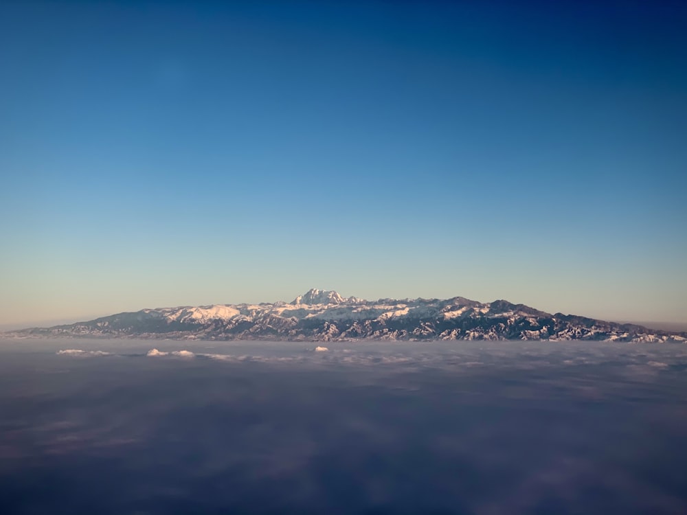 view photography of black and gray mountain during clear blue sky