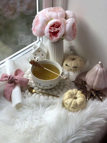 A cozy, feminine tea shop corner with pale pink and white stripes and delicate tea cups.