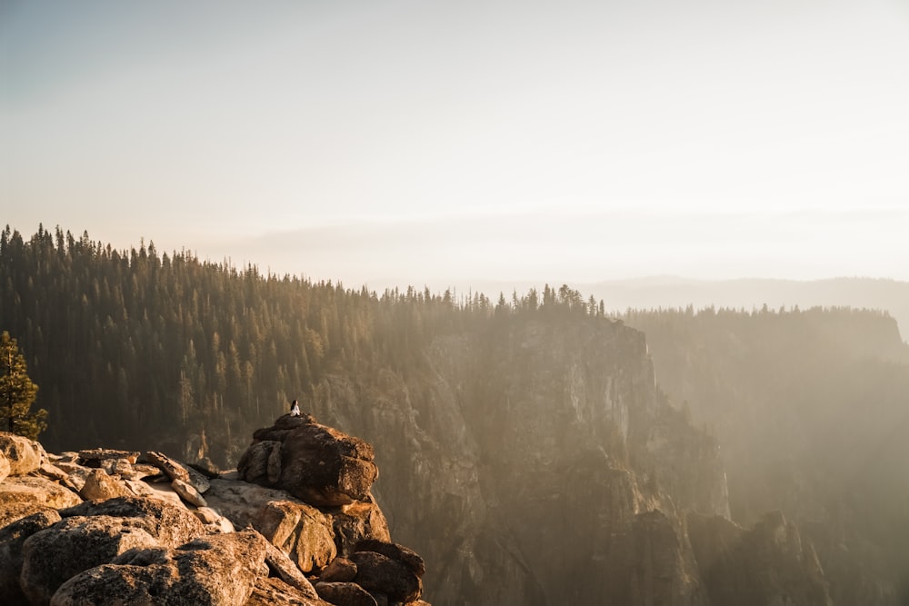 person sitting on boulder