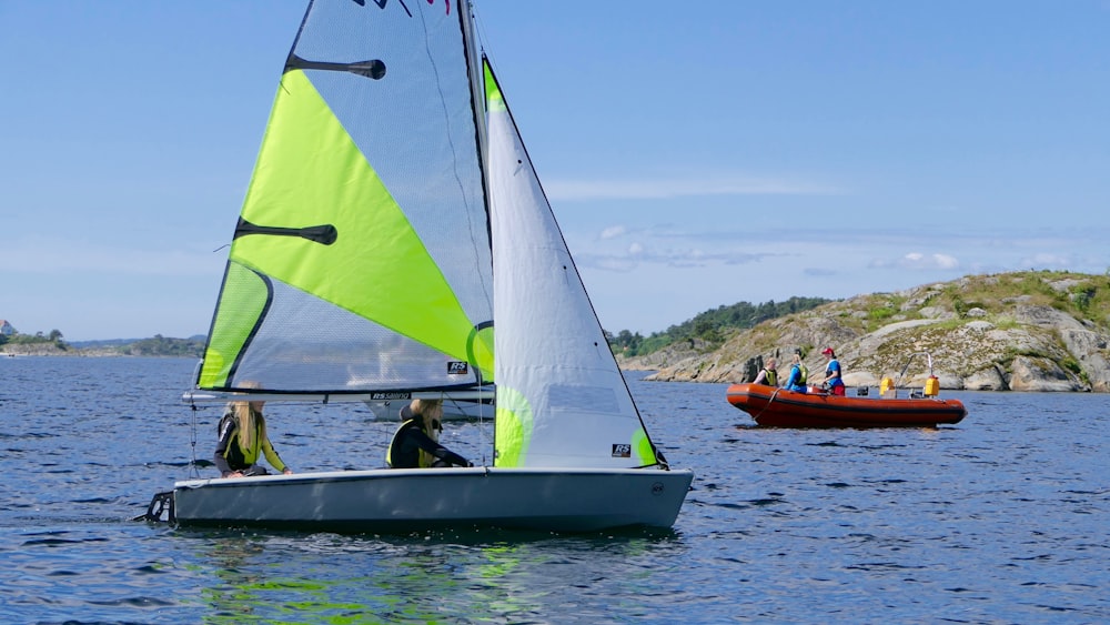 two person riding on white sailboat