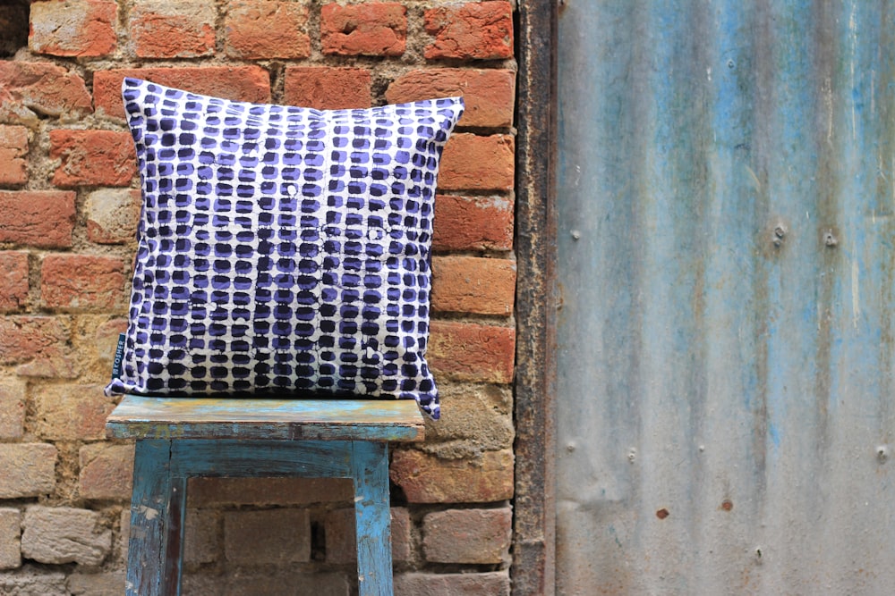 coussin blanc, noir et violet sur tabouret carré