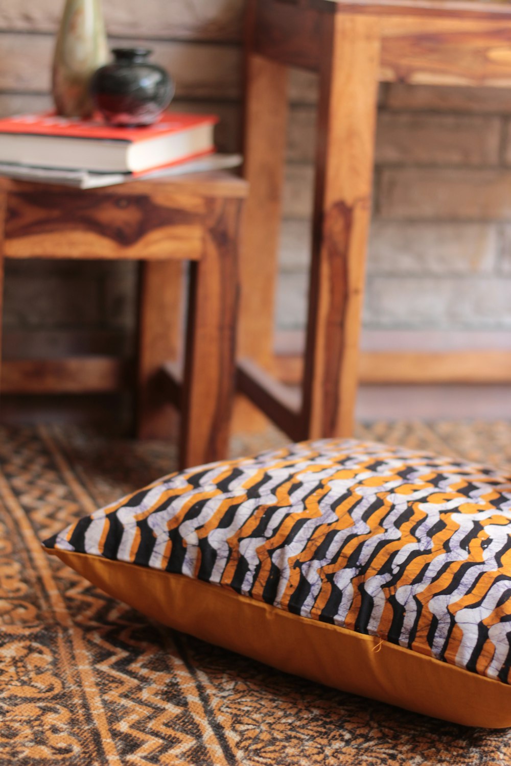 selective focus photo of white, black, and orange throw pillow