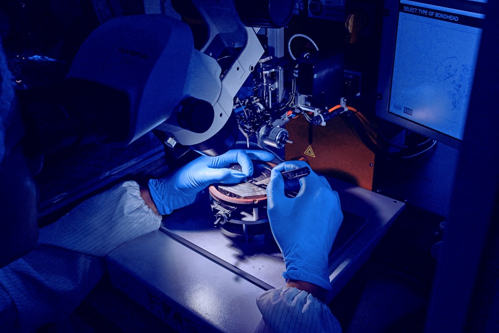 a person in blue gloves operating a machine