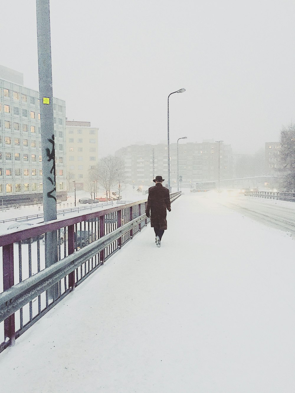 雪に覆われた橋の上を歩く女性