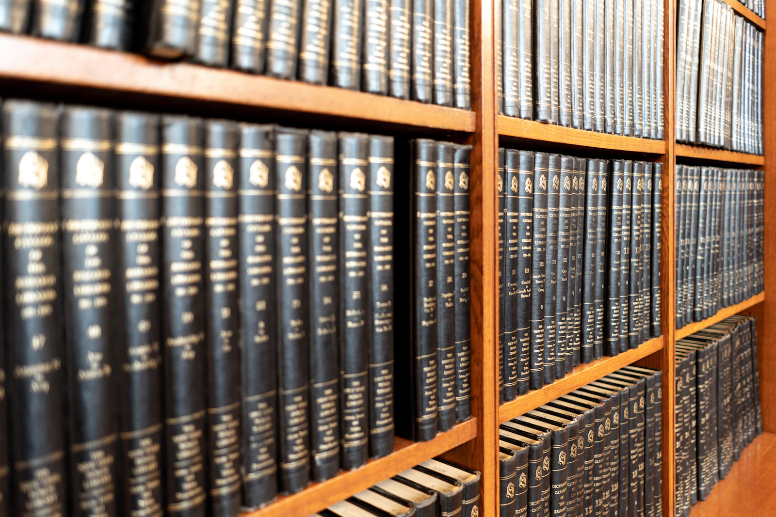 A single dark bound volume standing among books on a shelf
