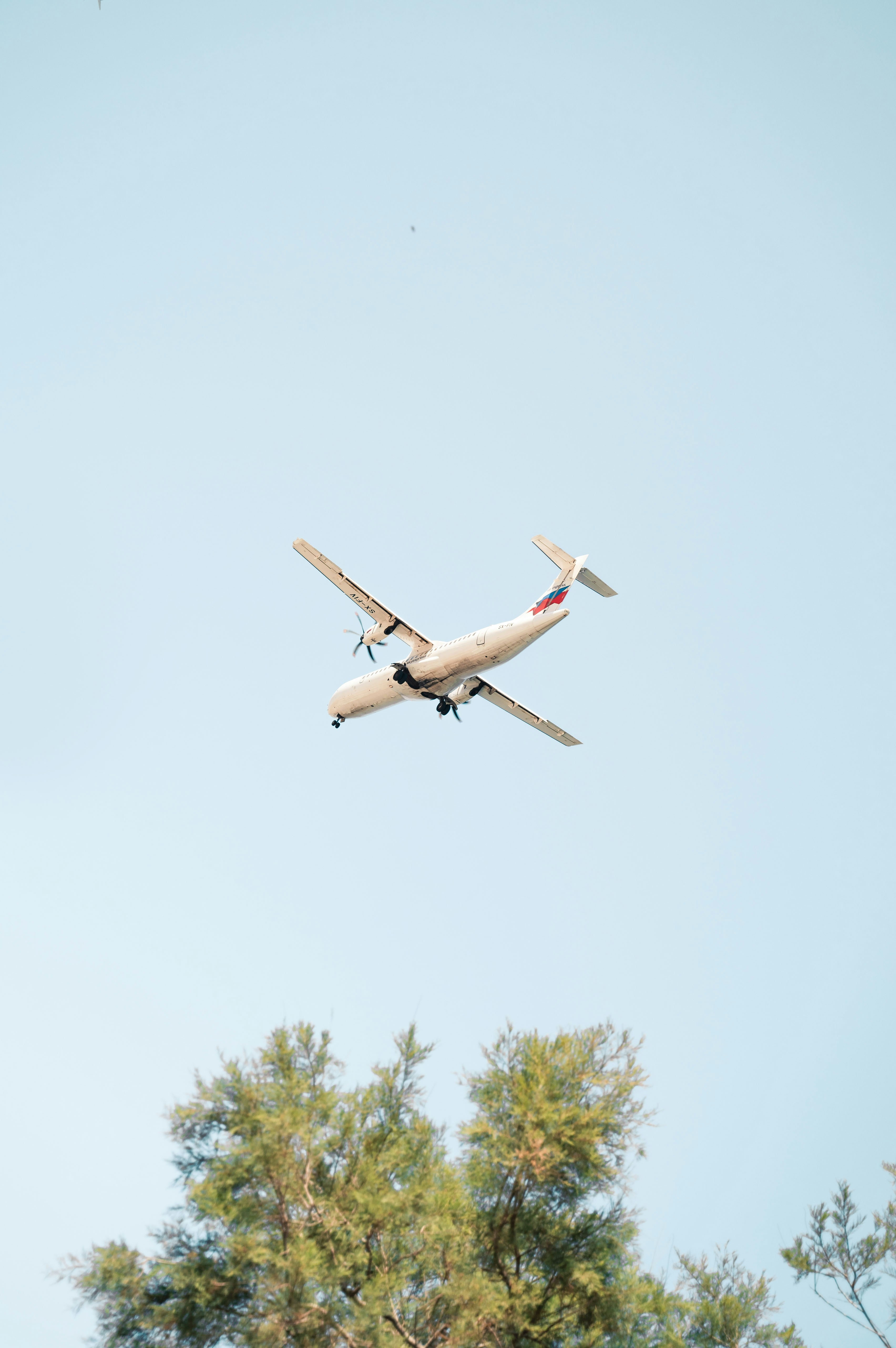 white airplane flying during daytime