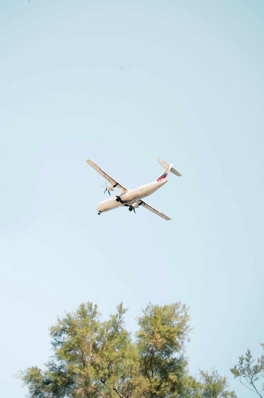 white airplane flying during daytime