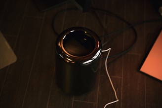 Close-up of hands setting up a sleek, high-tech device on a desk.